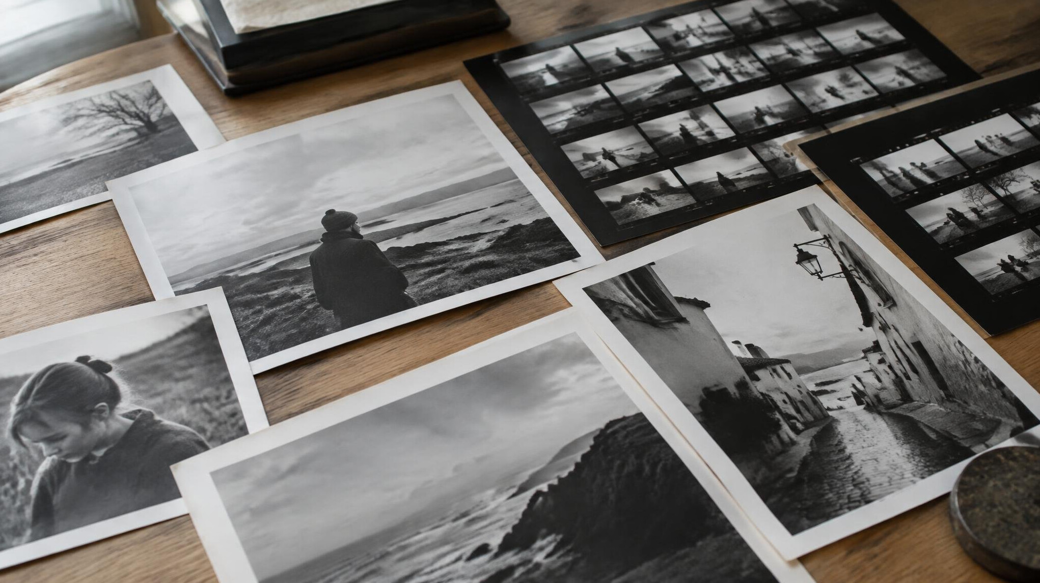 Printed photographs and contact sheets spread out on a table