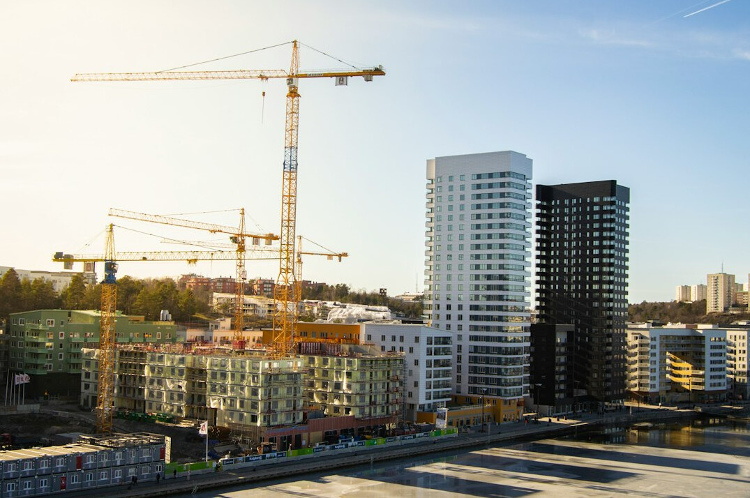 Construction site with cranes next to old buildings in a city under renovation