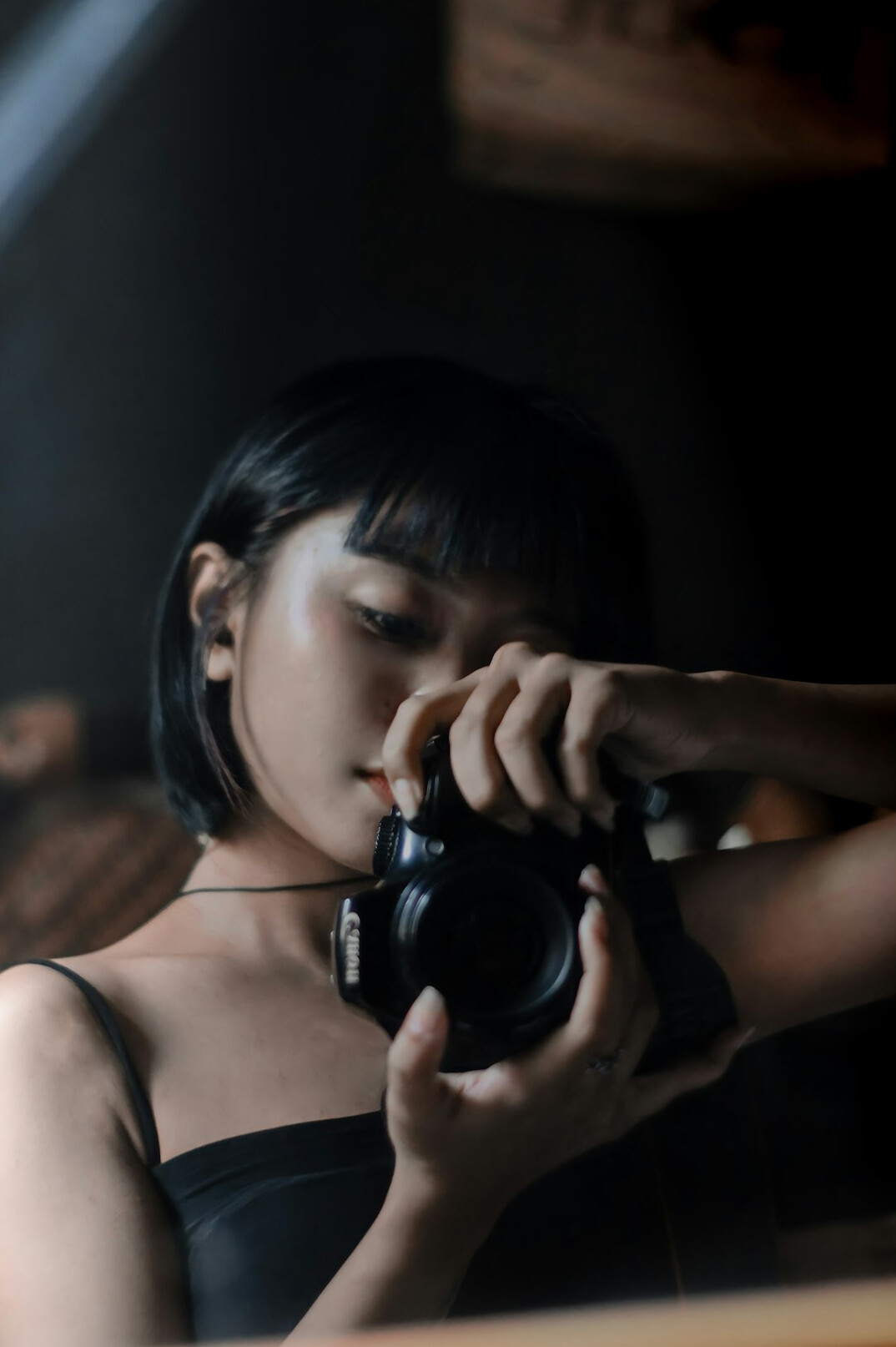 Studio portrait of a young woman photographer with a camera around her neck
