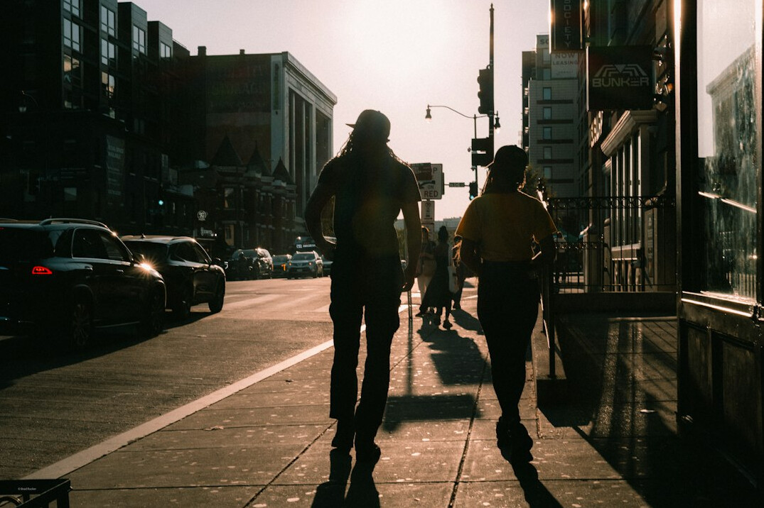 Commuters walking briskly through a city sidewalk in the morning