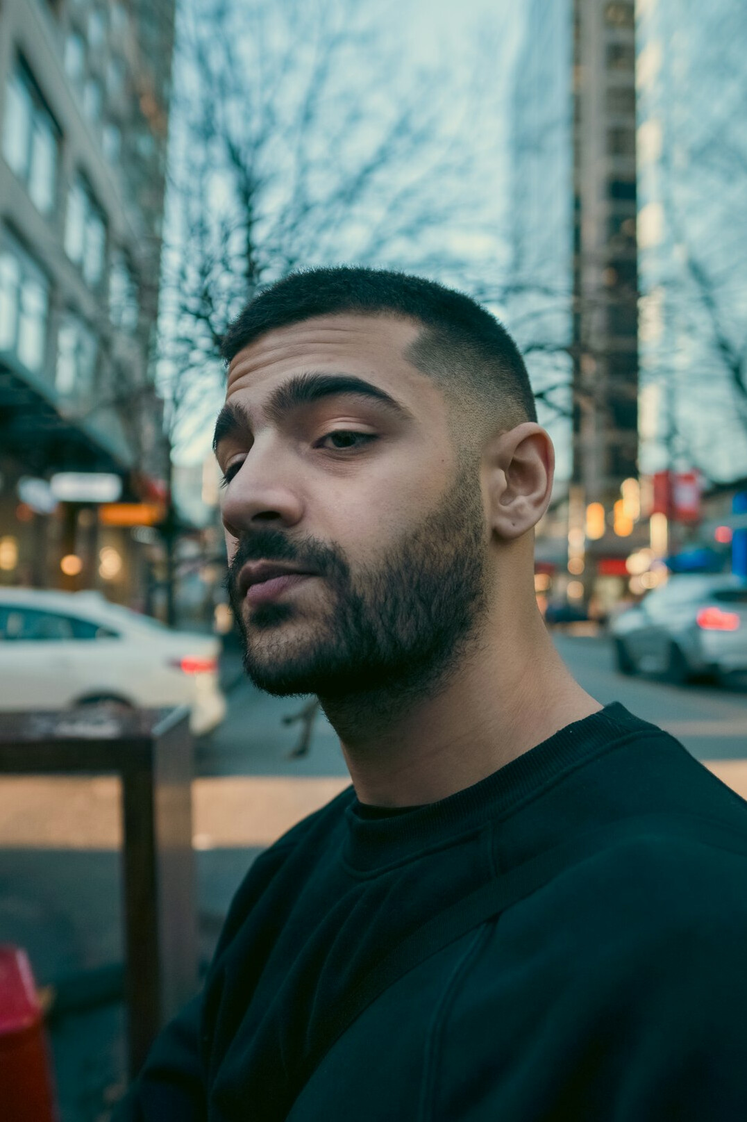Close up portrait of a man on a city street looking directly at the camera